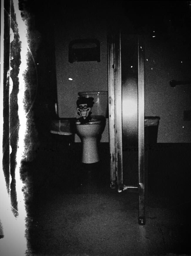 Spamton che fissa Spamton minacciosamente dalla tavoletta del bagno